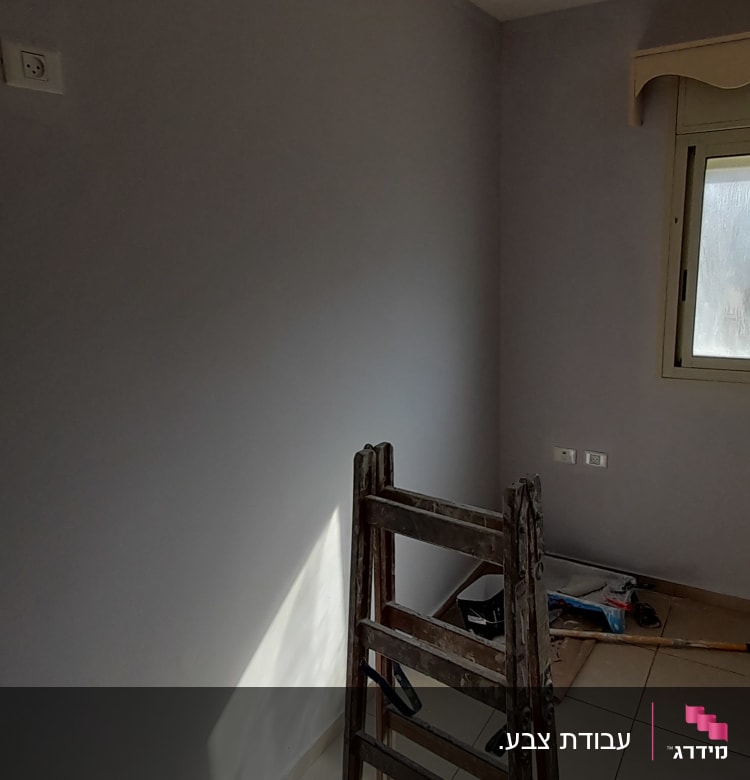 סולם עץ ליד קיר צבוע, כלים לצביעה על הרצפה